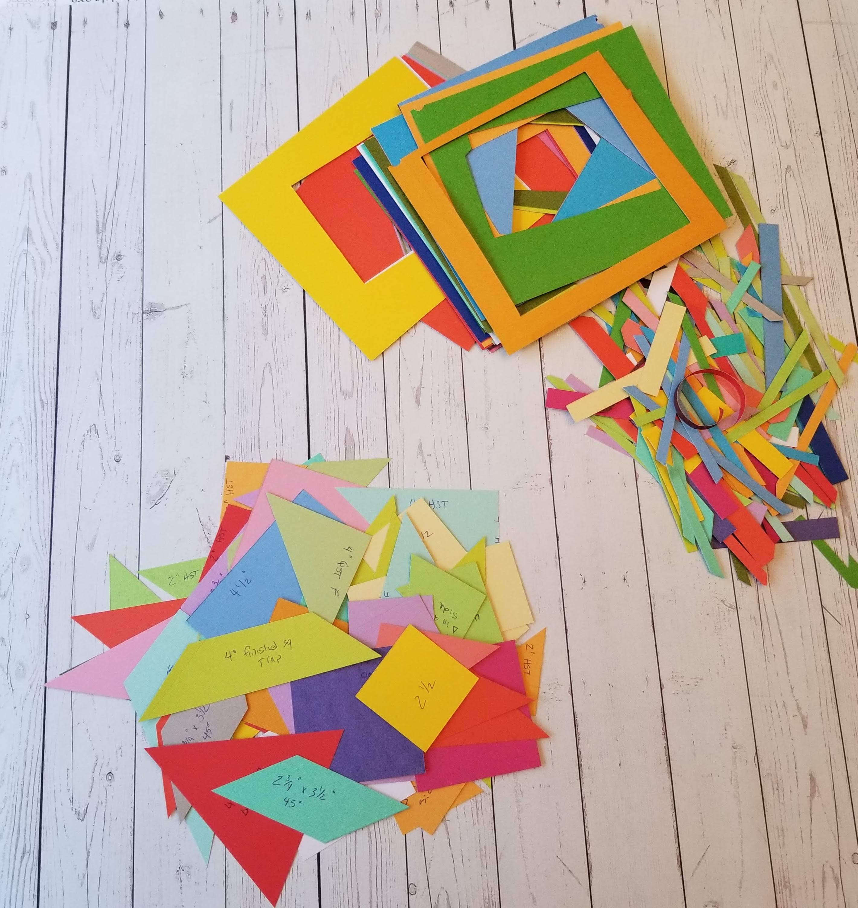 Multicolored shapes next to paper scraps on wood backdrop