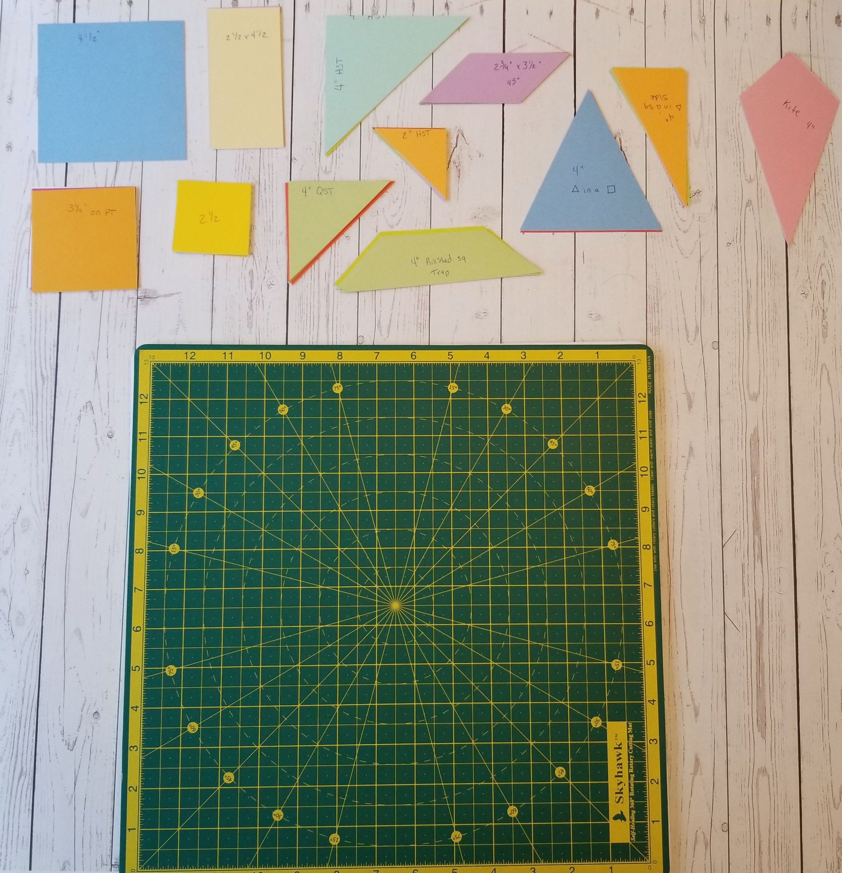 Multicolored paper shapes next to self healing cutting mat