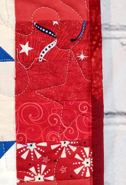 Close Up of the Binding on the Scrappy Patriotic Log Cabin Star Quilt
