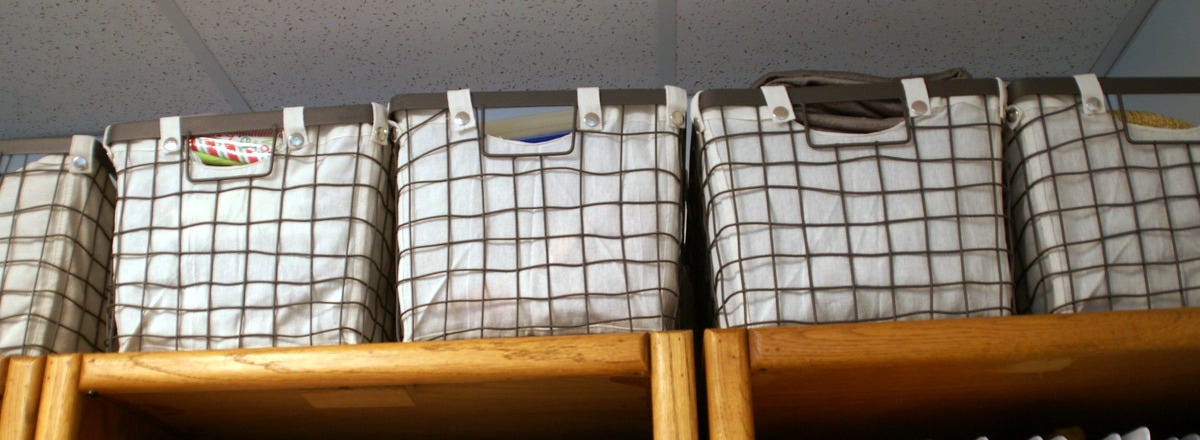 metal basket with canvas liner on book shelf