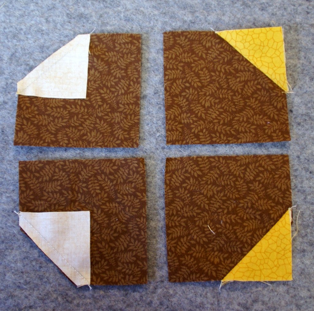 sunflower center block with brown fabrics and yellow corners on wool pressing mat