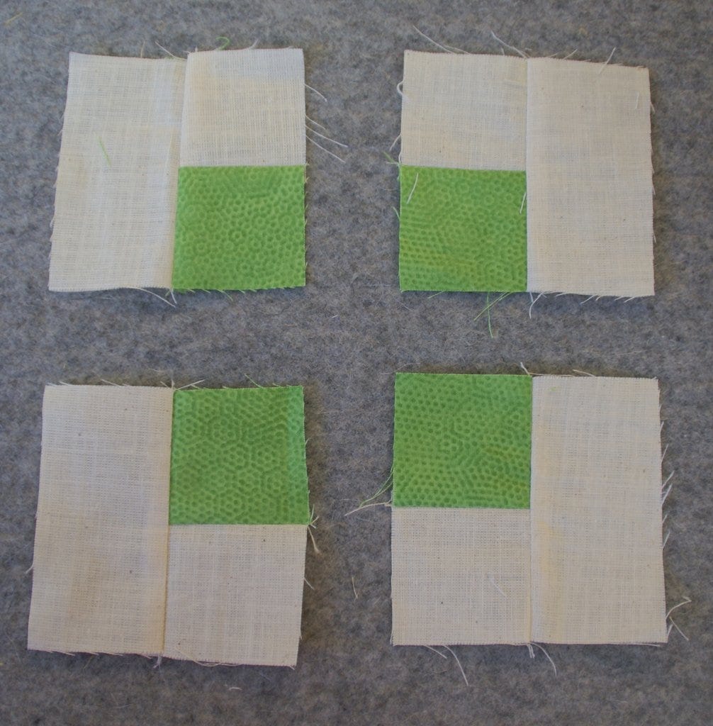 white and green squares and rectangles sewn as sunflower leaves on wool mat