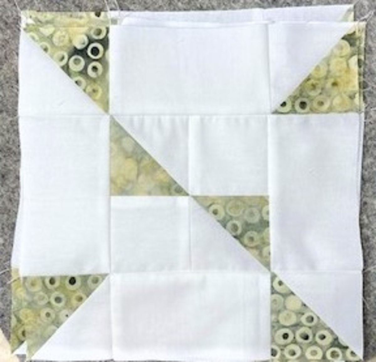 accuquilt half square triangle chain block with white and green and yellow batiks