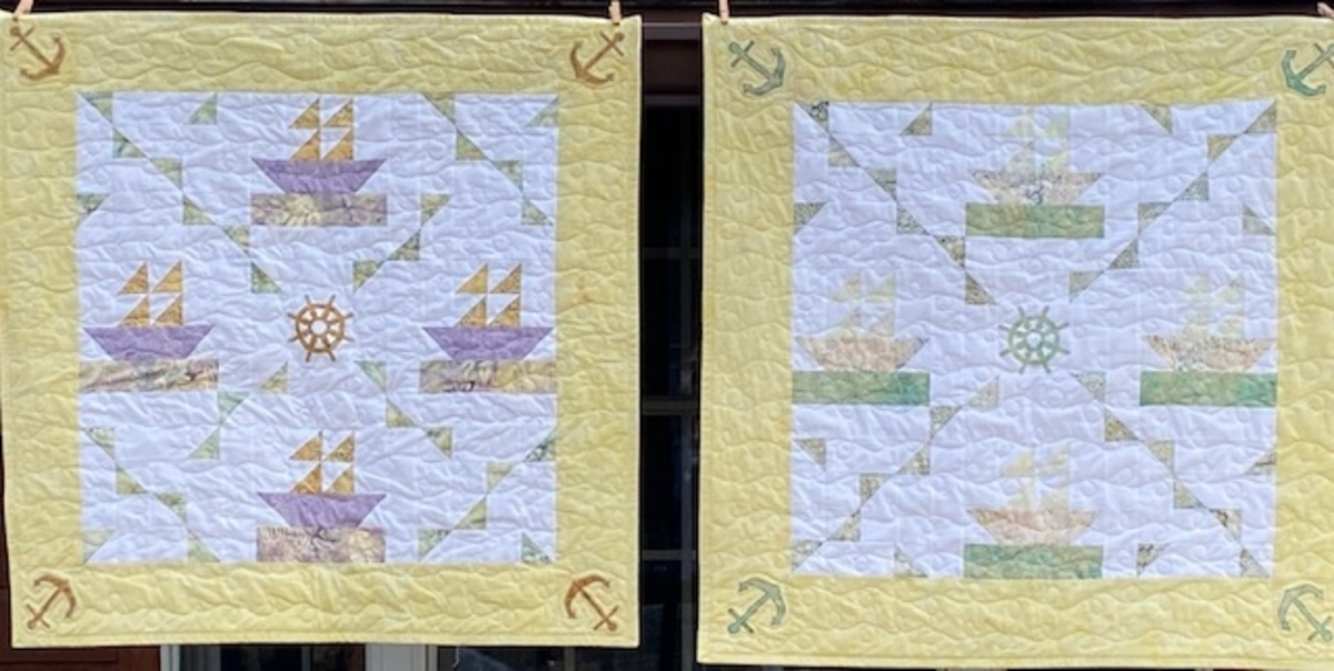 two side by side pieced sailboat baby quilt in different color variations, one with green and yellow and the other in purple and yellow