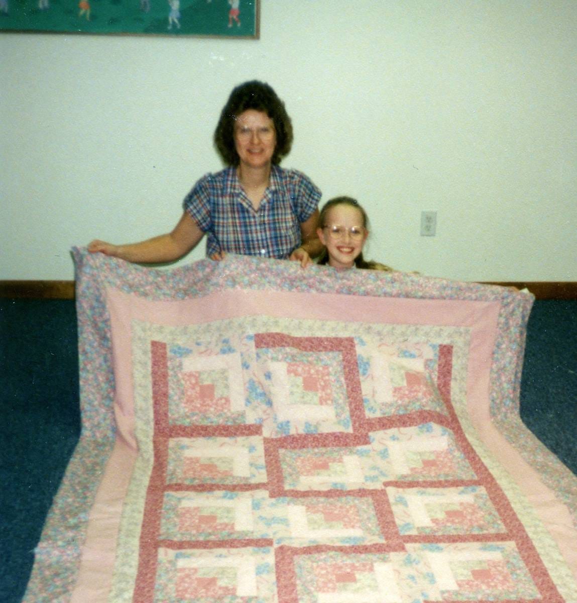 Old photo of Joy and her mother proudly sharing Joy's first quilt